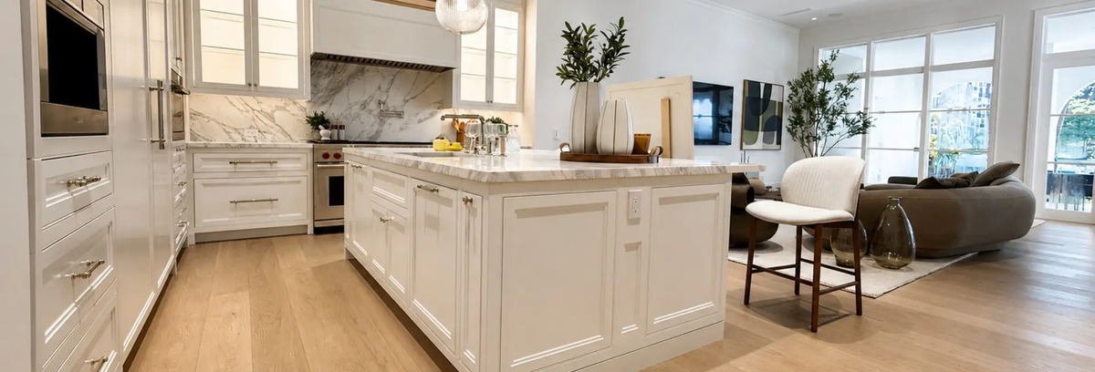 Open-concept kitchen and adjoining family room with matching wood flooring continuing across both spaces.