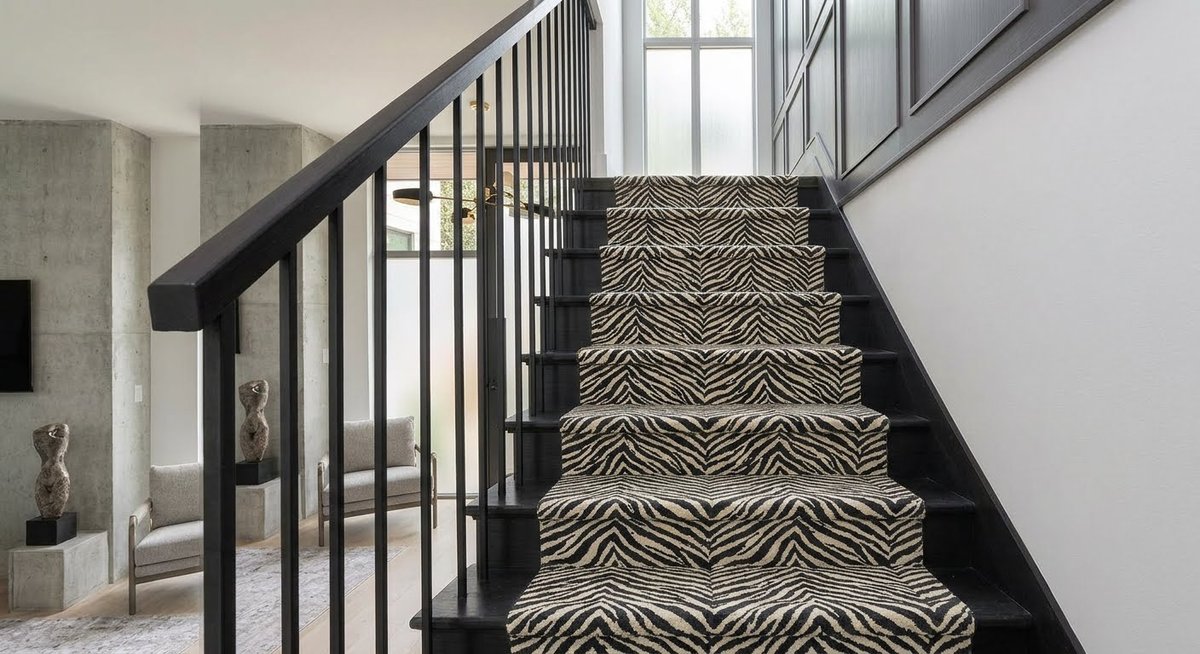 Contemporary staircase with an animal-print carpet runner and visible wood stair details.